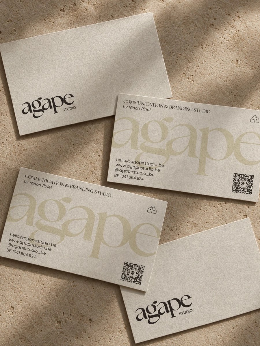 Les cartes de visite d'Agape Studio, imprimées sur papier coton, posées sur une pierre claire